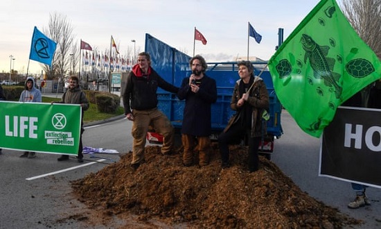 Activists dump manure outside the COP25 climate talks congress in Madrid on Saturday