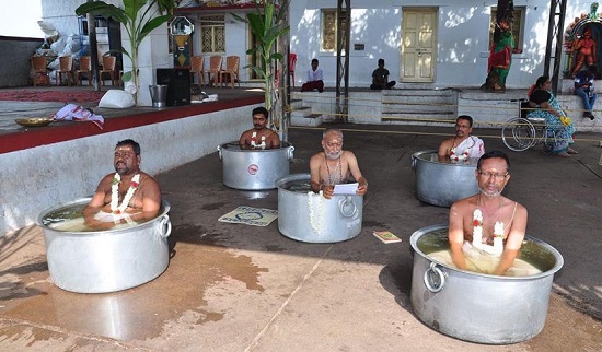 Hindu priests in tubs
